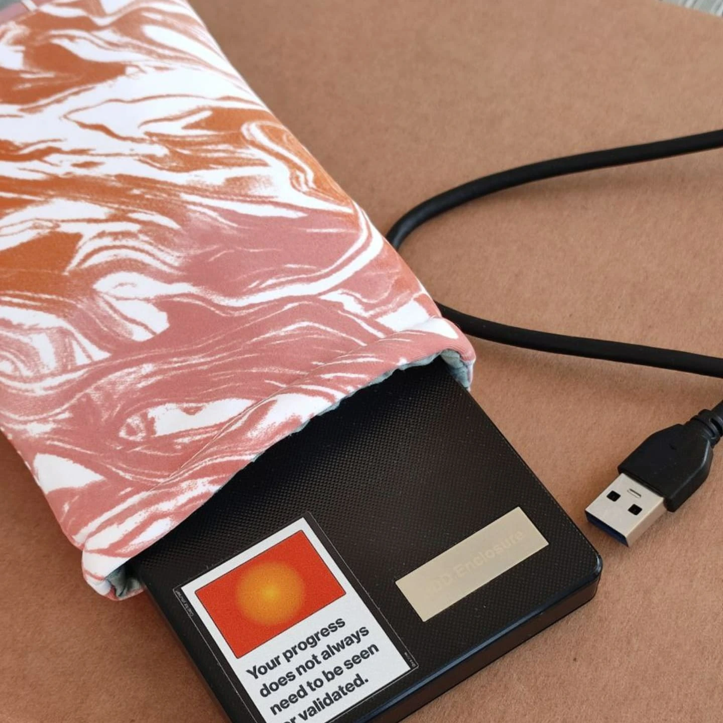 orange marbled laptop sleeve with a hard drive